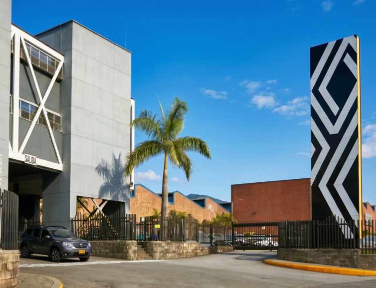 Vista exterior de la entrada principal de la planta de ensamble de Renault-Sofasa en Envigado, destacando la portería y el tótem con el nuevo emblema del rombo.