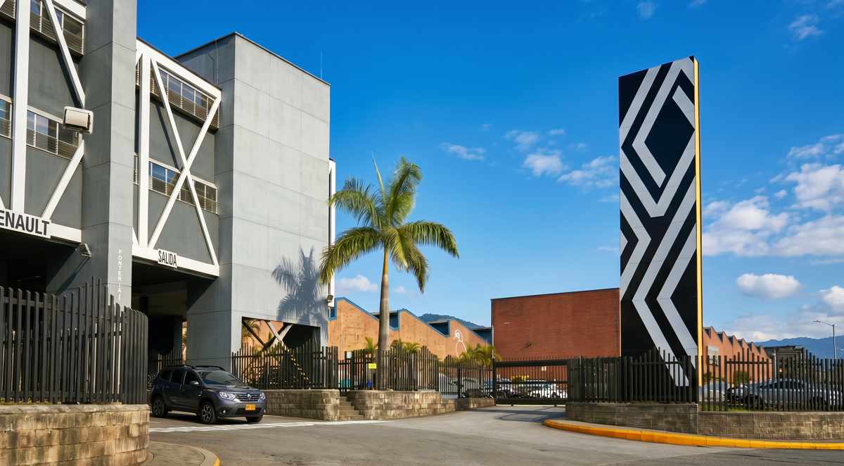 Vista exterior de la entrada principal de la planta de ensamble de Renault-Sofasa en Envigado, destacando la portería y el tótem con el nuevo emblema del rombo.