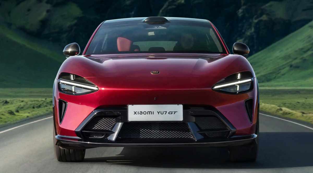 Vista frontal del nuevo SUV eléctrico deportivo Xiaomi YU7 GT color rojo carmesí circulando por una carretera, resaltando su diseño aerodinámico y faros LED.