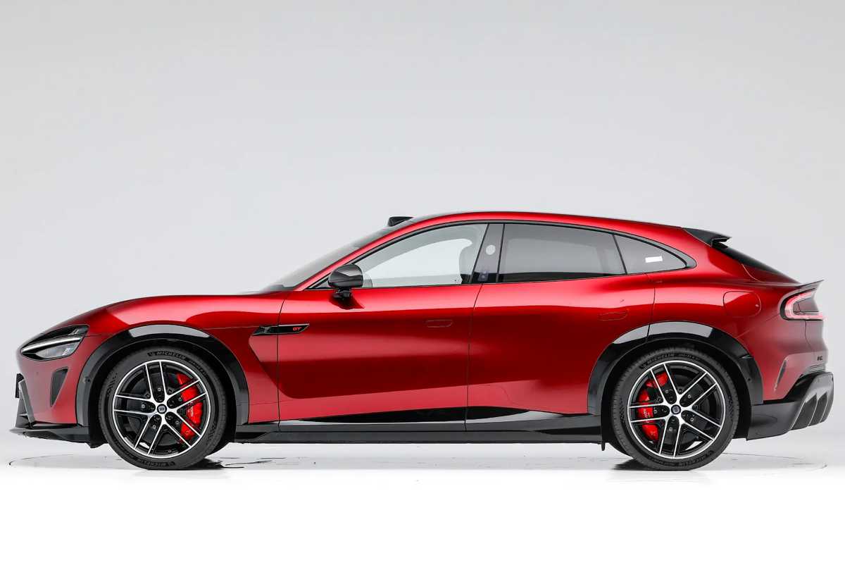 Vista lateral completa del Xiaomi YU7 GT en color rojo, mostrando su silueta alargada, baja altura al piso y rines deportivos con pinzas de freno rojas.