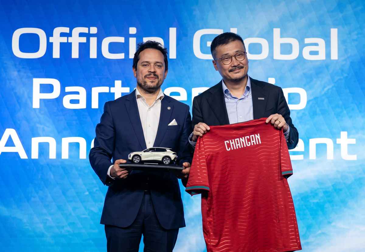 Directivos de Changan y representantes del equipo europeo sosteniendo con orgullo una camiseta roja de la selección de Portugal estampada con la marca Changan, junto a un modelo a escala.