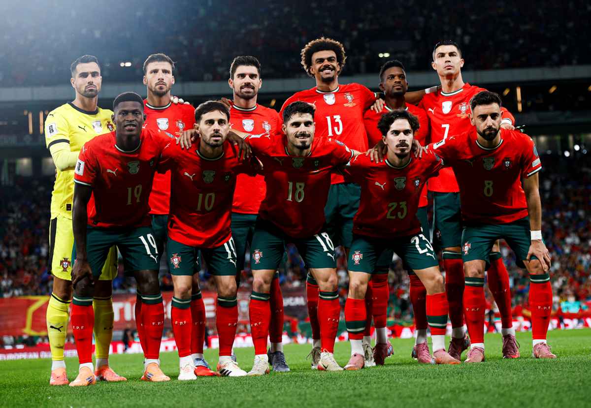 Alineación titular oficial de la selección de fútbol de Portugal, vistiendo su tradicional uniforme rojo y verde, abrazados en la cancha antes de un partido internacional.