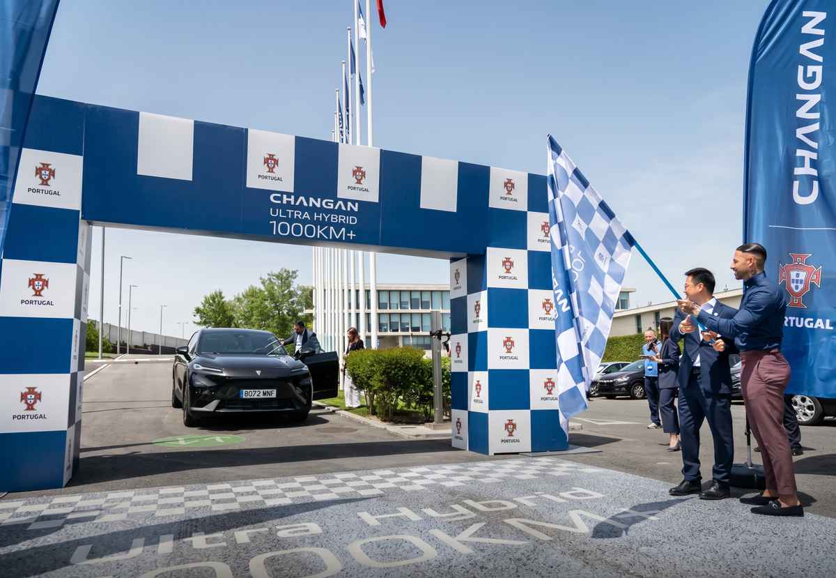 Banderazo de salida de la ruta de prueba europea de Changan, mostrando un SUV Deepal S05 gris cruzando bajo un arco de meta decorado con los colores y escudos de la selección de Portugal.