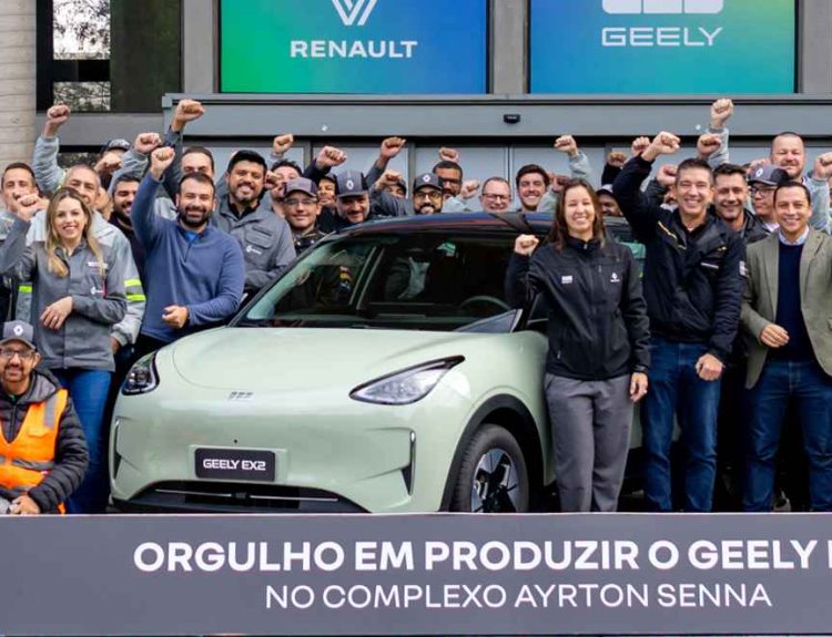 Grupo de directivos y trabajadores celebrando junto al carro eléctrico Geely EX2 color verde claro en el Complejo Ayrton Senna en Brasil, con logotipos de Renault y Geely en el fondo y un cartel conmemorativo de su producción sudamericana.