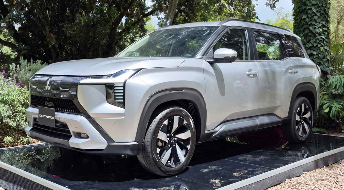 Vista tres cuartos delantera de la nueva camioneta de siete puestos Mitsubishi Destinator color Plata Metalizado, exhibida sobre una tarima reflectiva en Colombia.