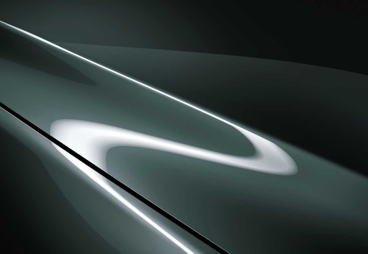 Detalle en primer plano de la carrocería de Mazda que muestra los reflejos lumínicos, sombras y las escamas metálicas de la inédita pintura Verde Zinc.