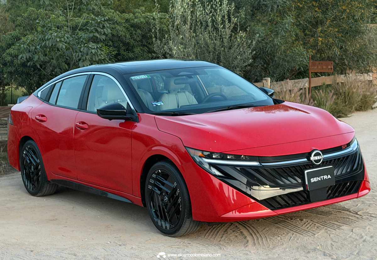 Plano tres cuartos delantero del Nissan Sentra 2027 SR Platinum rojo con techo negro, destacando sus rines deportivos bitono de 18 pulgadas con radios diagonales.