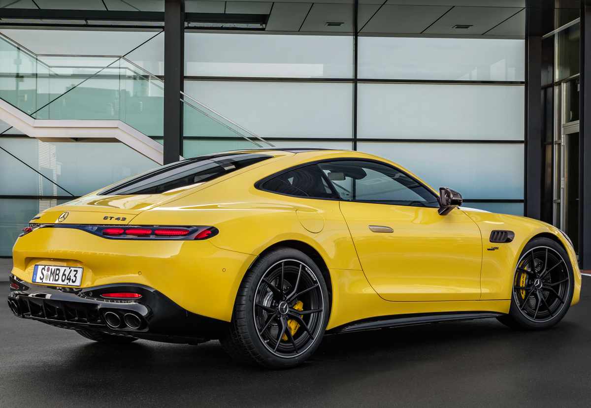 Perspectiva trasera de tres cuartos del Mercedes-AMG GT 43 en color amarillo, resaltando sus luces traseras delgadas conectadas y el agresivo difusor inferior.