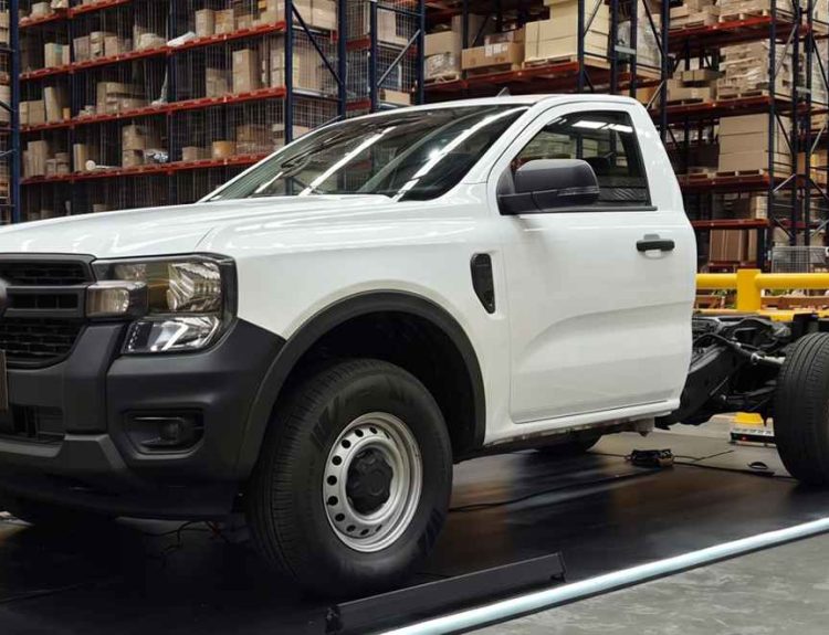 Ford Ranger XL Chasis color blanco exhibida sobre una plataforma negra con iluminación azul, destacando su estructura trasera desnuda y lista para carrozar durante su lanzamiento en Colombia.