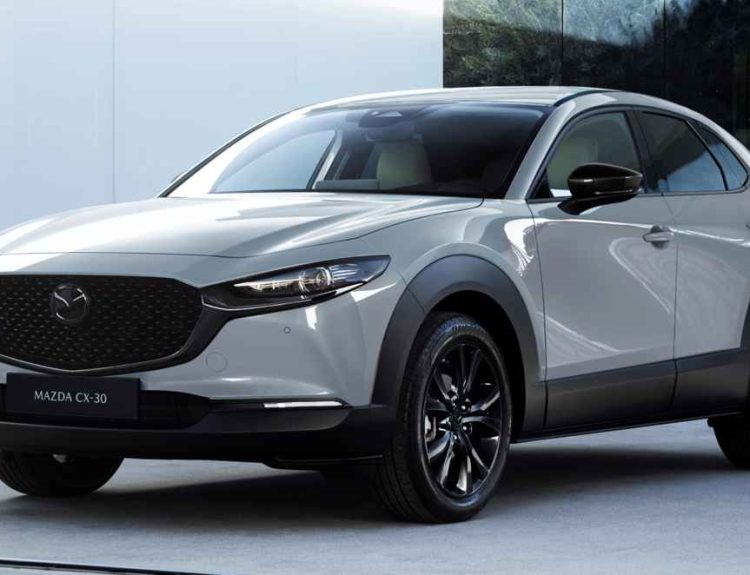 Vista frontal de tres cuartos de la renovada Mazda CX-30 2027 luciendo el inédito color exterior Gris Aéreo, destacando su gran parrilla negra y faros LED afilados.