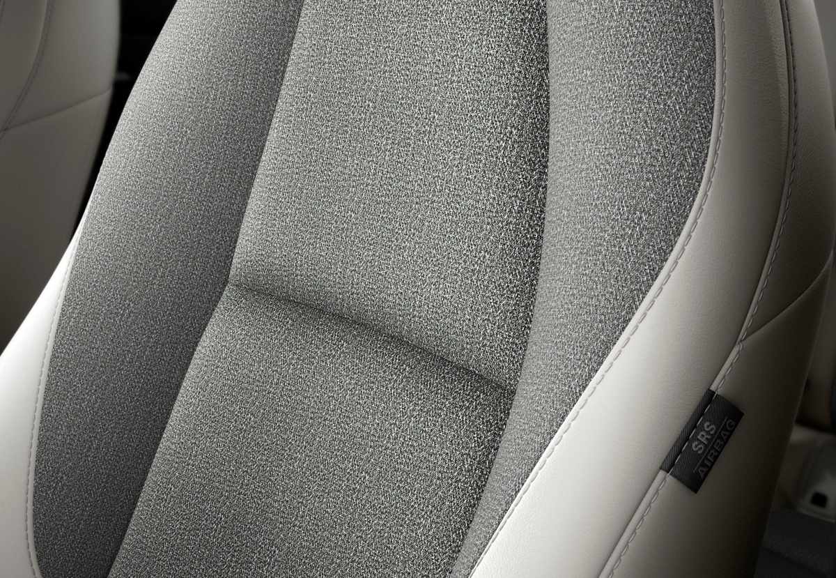 Detalle de los nuevos asientos delanteros de la Mazda CX-30 edición Makoto, exhibiendo la tapicería exclusiva que combina tonos gris claro y blanco con costuras de alta calidad.