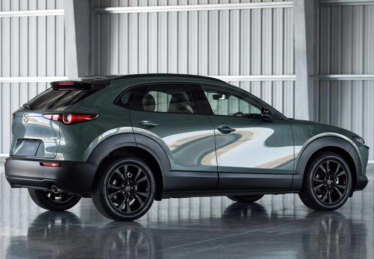 Silueta lateral trasera de la Mazda CX-30 2027 exhibiendo el nuevo color Verde Zinc, destacando sus rines de aleación oscurecidos y el perfil aerodinámico del exitoso crossover japonés.
