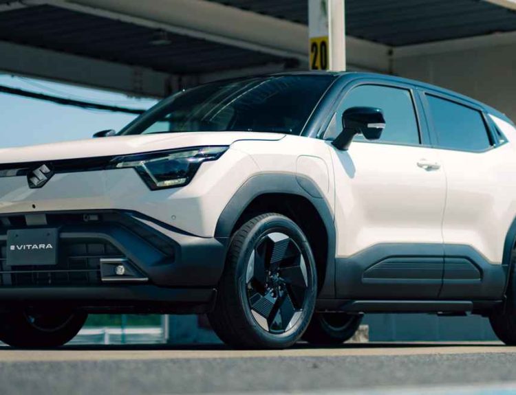 Vista frontal de tres cuartos del nuevo SUV eléctrico Suzuki e-Vitara color blanco brillante, destacando su diseño robusto, faros LED y rines aerodinámicos bajo luz natural.
