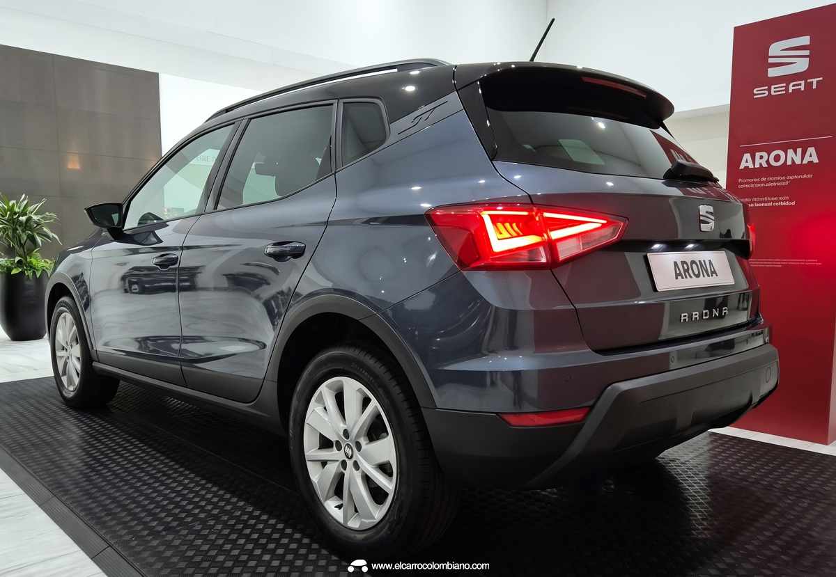 Perspectiva trasera de tres cuartos de la SEAT Arona 2026, mostrando sus luces traseras con firma lumínica triangular, techo negro en contraste y el ski plate plateado inferior.
