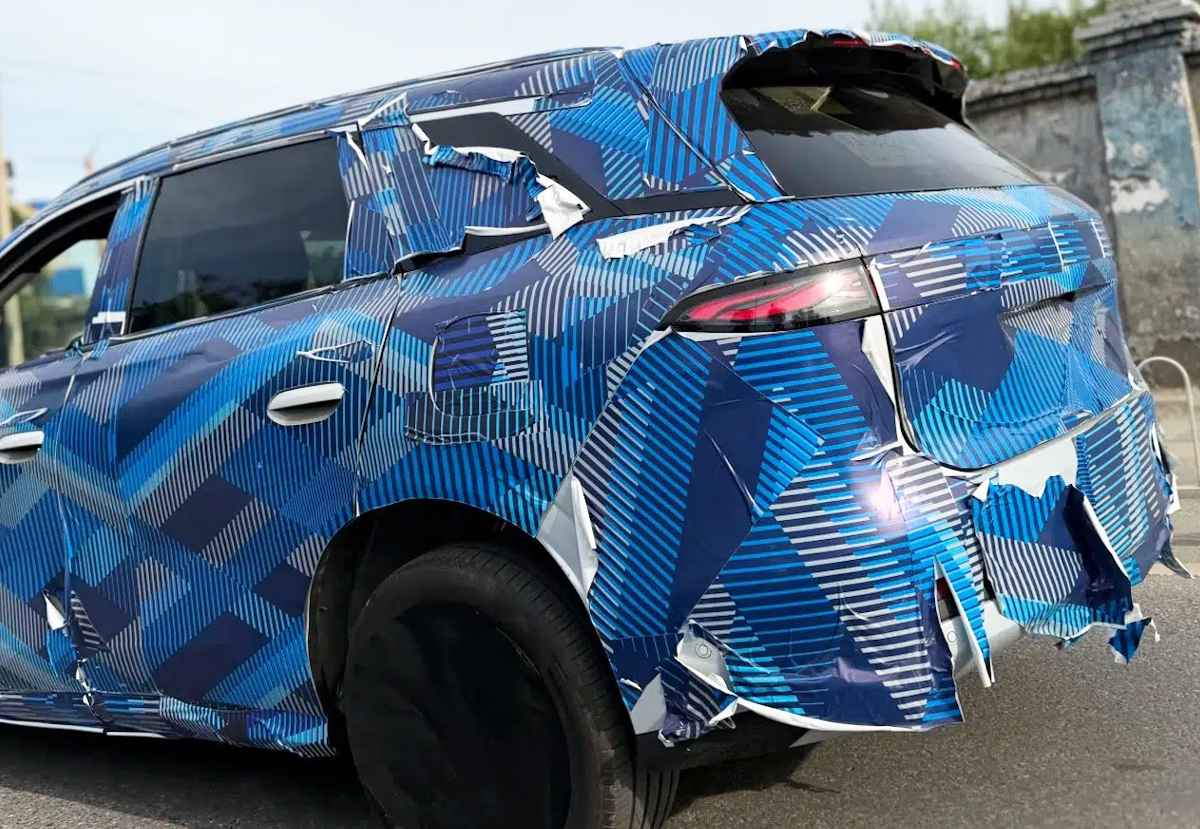 Primer plano de la sección posterior de la nueva BYD Tang en fase de pruebas, mostrando detalles de sus delgadas luces LED horizontales bajo el camuflaje.