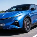 SUV eléctrico deportivo Alpine A390 GTS de color azul rodando a alta velocidad sobre el asfalto, destacando su diseño aerodinámico frontal y rines en movimiento.