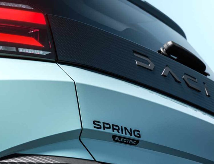 Detalle de la compuerta trasera del nuevo Dacia Spring eléctrico en color azul claro, mostrando el faro LED, la franja negra texturizada con la inscripción Dacia y el emblema Spring Electric.
