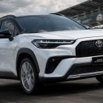SUV deportivo Toyota Corolla Cross GR Sport 2027 de color blanco rodando en una pista de carreras, mostrando su nuevo diseño de bómper y parrilla frontal.
