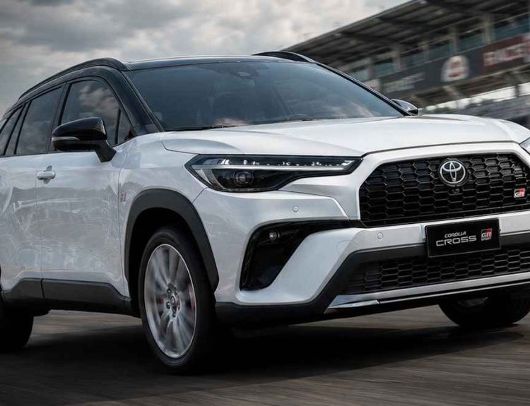 SUV deportivo Toyota Corolla Cross GR Sport 2027 de color blanco rodando en una pista de carreras, mostrando su nuevo diseño de bómper y parrilla frontal.