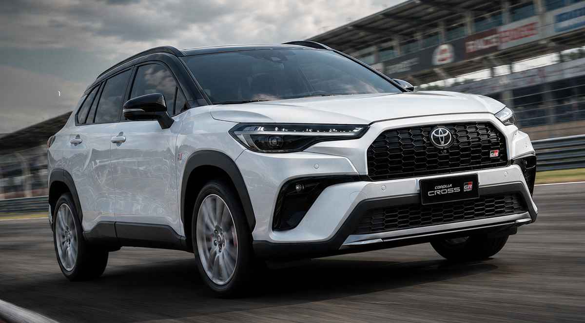 SUV deportivo Toyota Corolla Cross GR Sport 2027 de color blanco rodando en una pista de carreras, mostrando su nuevo diseño de bómper y parrilla frontal.