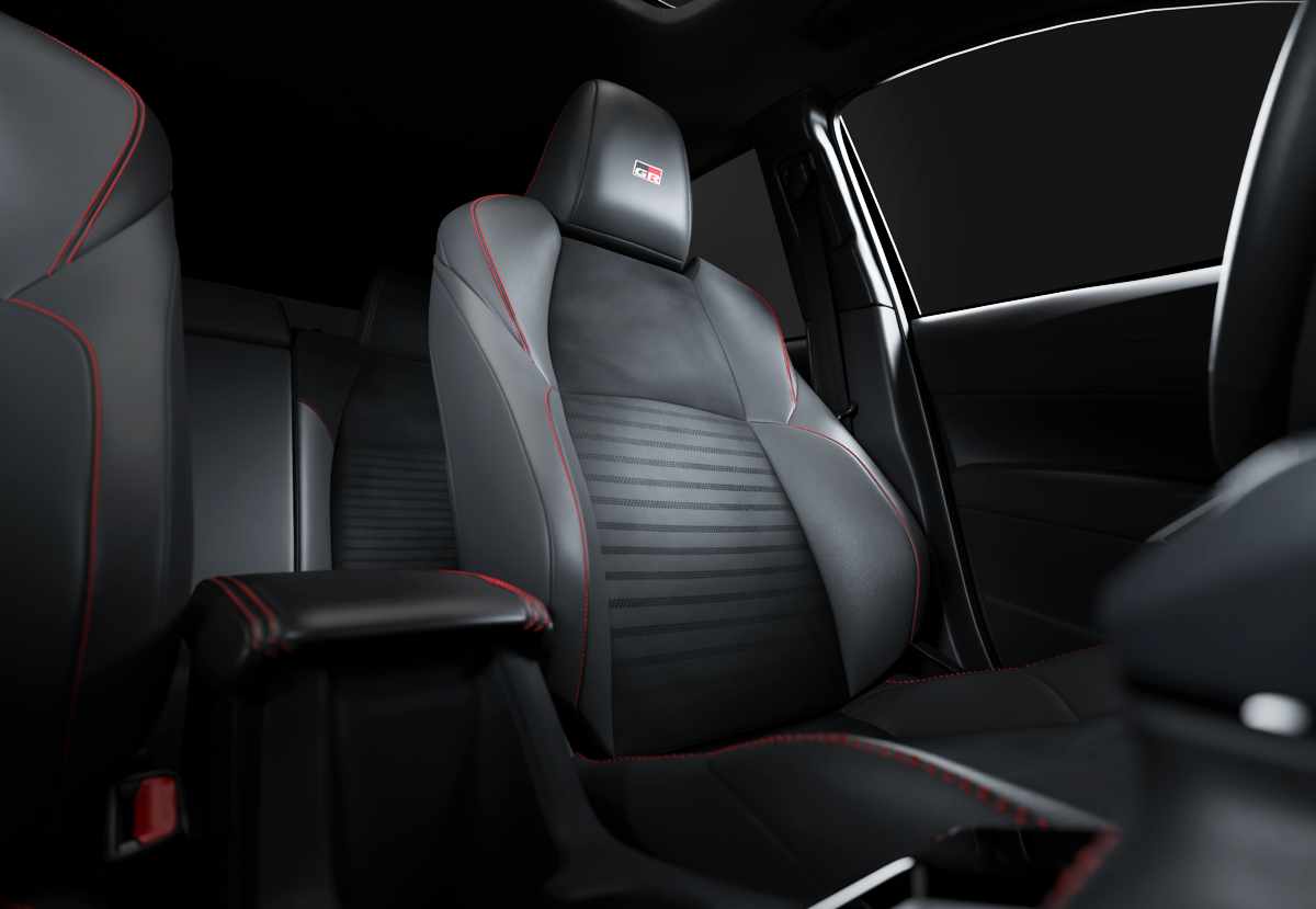 Silla deportiva delantera del Toyota Corolla Cross GR Sport con tapicería oscura, costuras decorativas rojas y el logotipo GR bordado en el apoyacabezas.