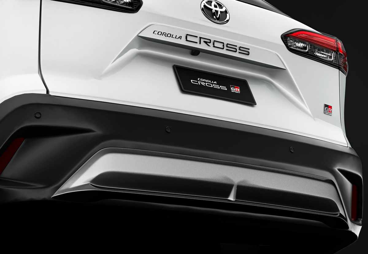 Toma en ángulo bajo de la zona trasera del Toyota Corolla Cross, enseñando el nuevo acabado del portón del baúl, las molduras oscuras y el bómper inferior estilizado.