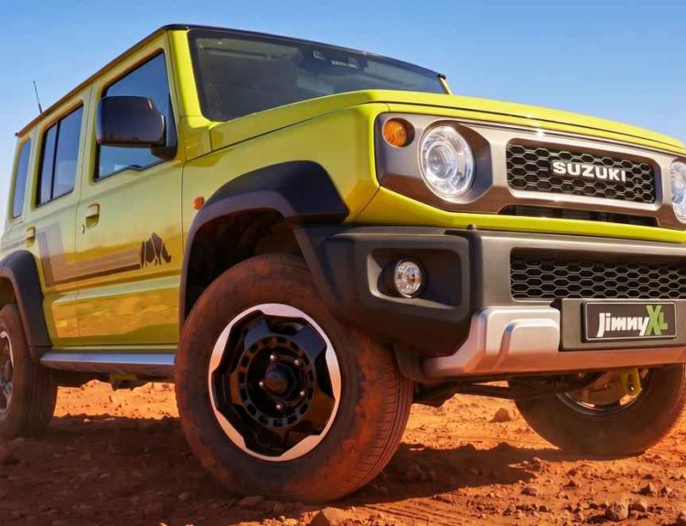 Vista en plano contrapicado tres cuartos del Suzuki Jimny XL Rhino Special Edition color Amarillo Cinético en un terreno desértico, destacando su parrilla clásica y rines negros.