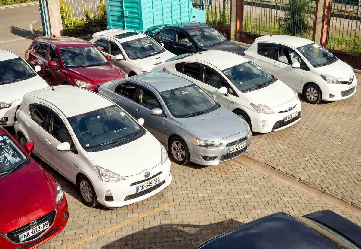 Vista aérea de un lote o puerto de almacenamiento repleto de automóviles usados de origen japonés de diversos colores y modelos estacionados en filas compactas.