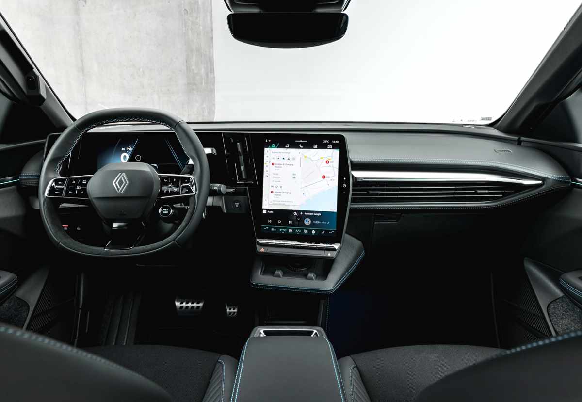 Habitáculo interior del Renault Mégane E-Tech 2027 destacando el panel digital continuo en forma de L con la pantalla táctil de 12 pulgadas y los detalles de costuras azules.