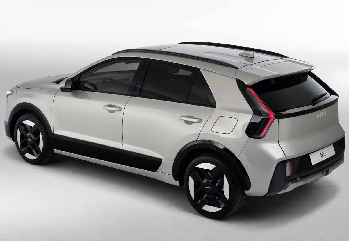 Vista posterior tres cuartos de la Kia Niro 2027 en estudio, exhibiendo sus características luces traseras verticales en forma de boomerang pegadas a la luneta y el paral trasero aerodinámico.