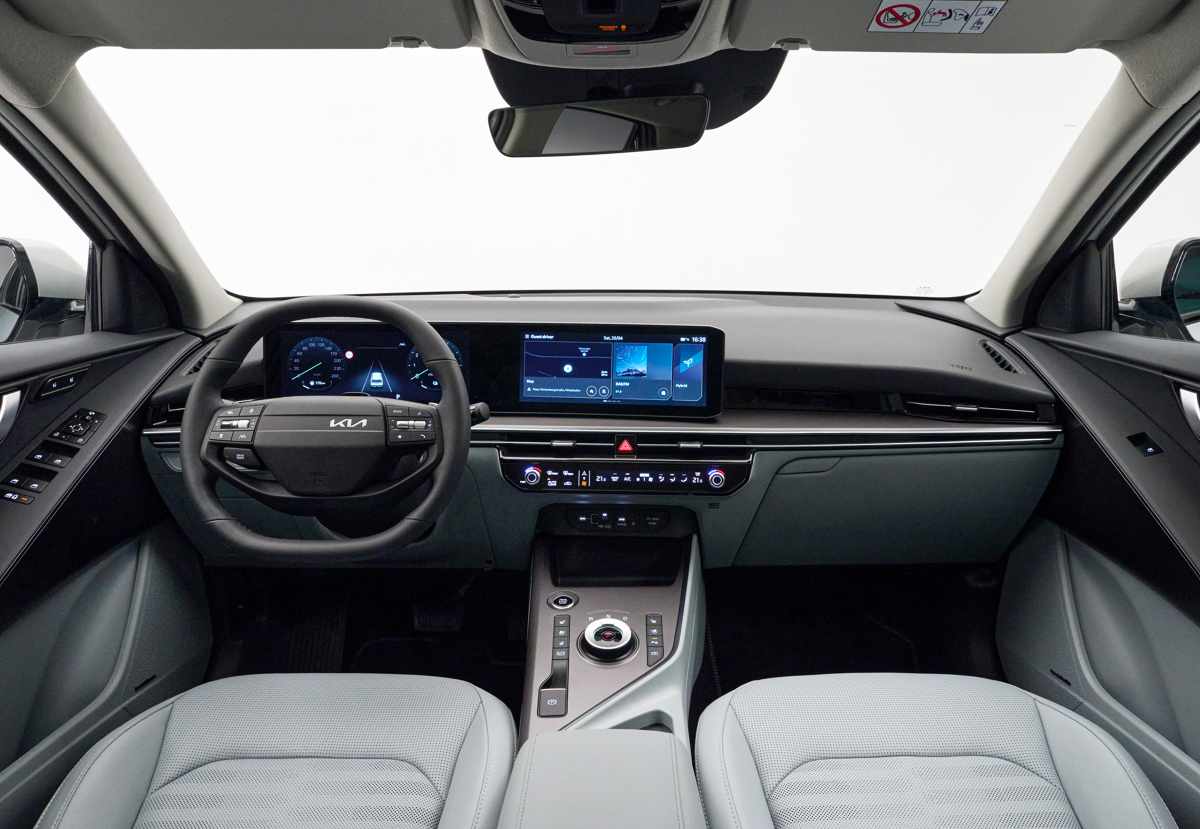 Interior de la cabina de la nueva Kia Niro 2027, mostrando el tablero digital y la pantalla táctil central de 12,3 pulgadas en un solo panel continuo, junto al volante de dos radios y consola central.