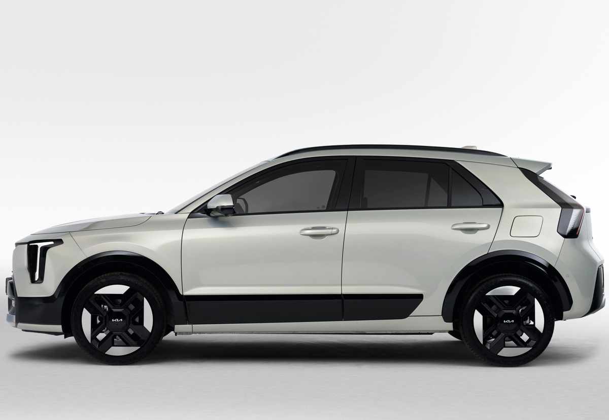 Perfil lateral completo de la SUV Kia Niro 2027 sobre fondo blanco, detallando su distancia entre ejes, los rines bitono de 18 pulgadas, las barras de techo y el alerón trasero superior.