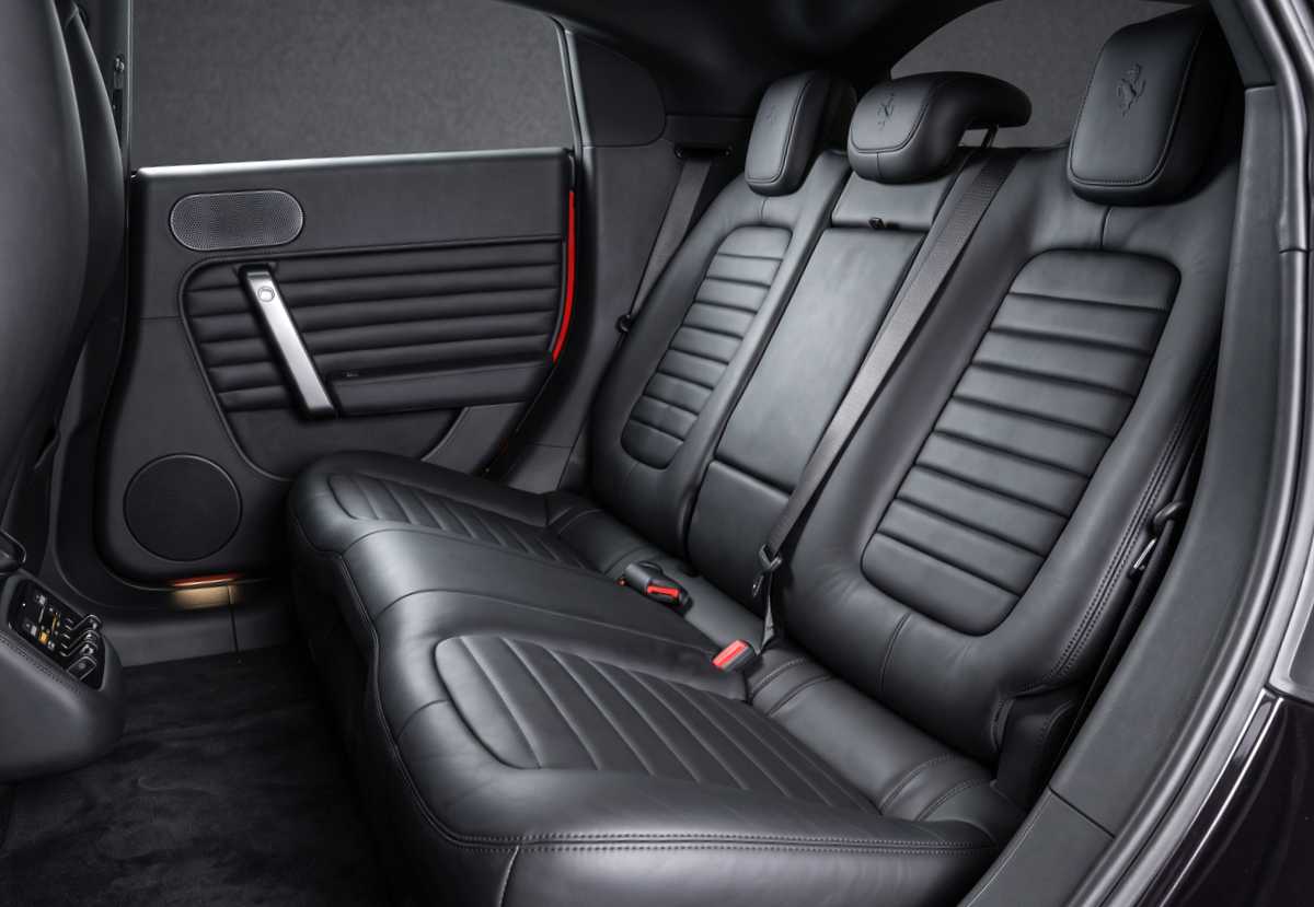 Asientos traseros del Ferrari Luce tapizados en cuero negro, mostrando el confort y espacio interior del gran turismo eléctrico.
