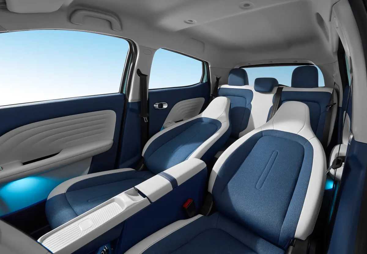 Asientos ergonómicos del interior del JMEV 3 en tonos azul y blanco, resaltando la mejora del espacio y habitabilidad del vehículo urbano.