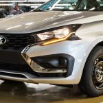 Primer plano frontal del nuevo Lada Iskra SW Drive plateado en fábrica, mostrando sus detalles cromados y su rin de acero negro de 15 pulgadas.