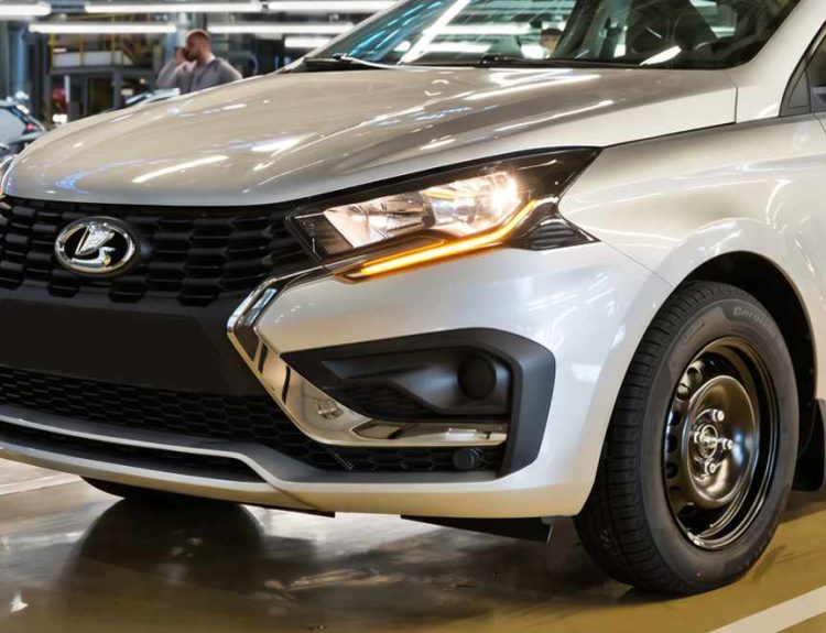 Primer plano frontal del nuevo Lada Iskra SW Drive plateado en fábrica, mostrando sus detalles cromados y su rin de acero negro de 15 pulgadas.