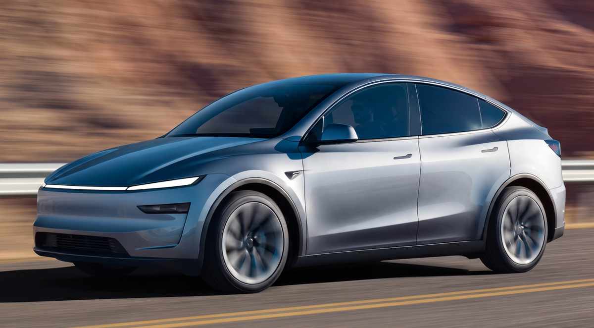 Tesla Model Y plateado en movimiento por una carretera despejada con montañas de fondo, representando el carro más vendido de Colombia en mayo.