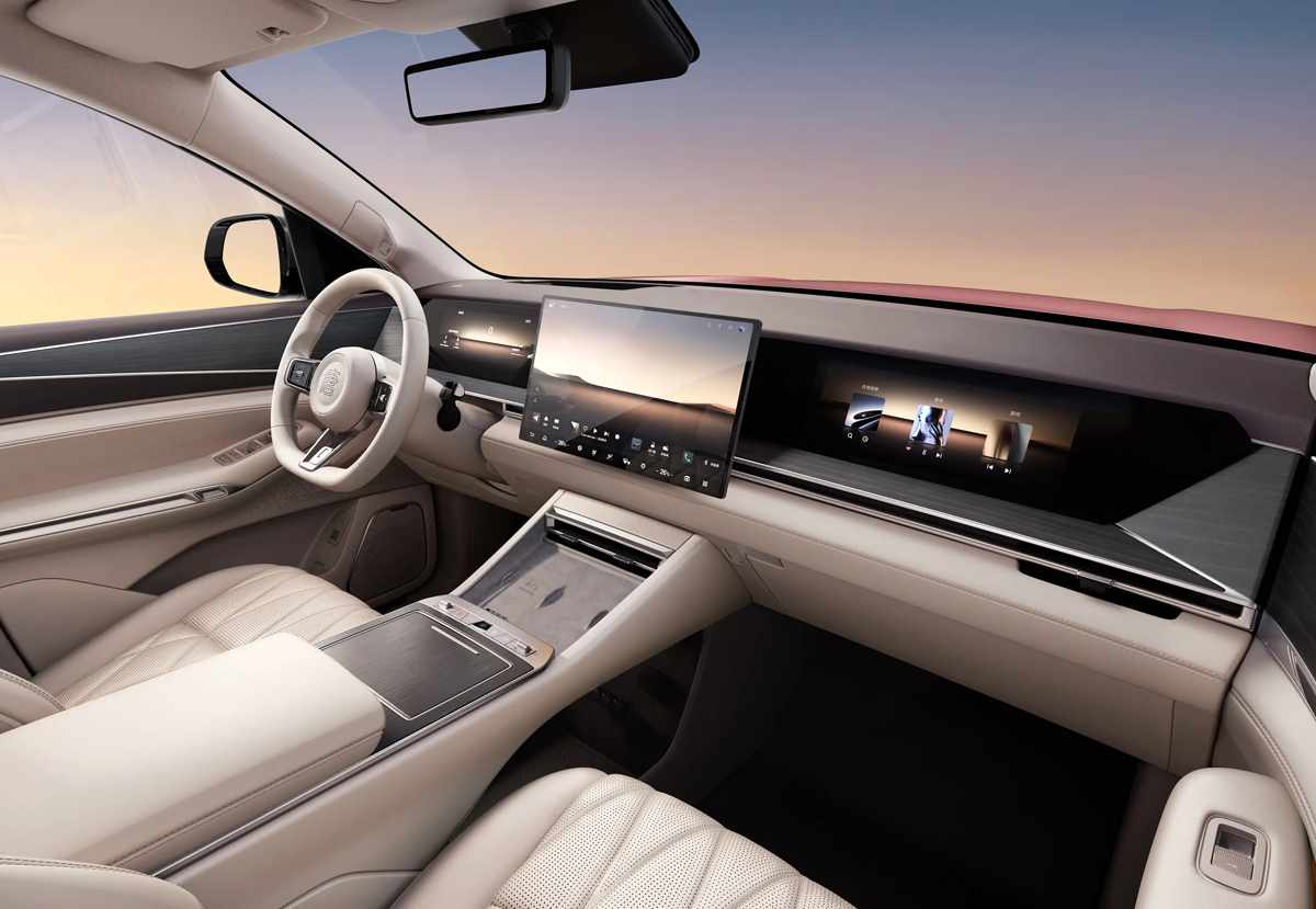 Diseño interior de la cabina de la BYD Great Tang, luciendo una pantalla central gigante, consola minimalista y volante forrado en cuero de tono claro.