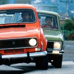 Tres clásicos Renault 4, 6 y 12 de colores naranja, verde y azul circulando en fila durante una prueba de ruta en Colombia.