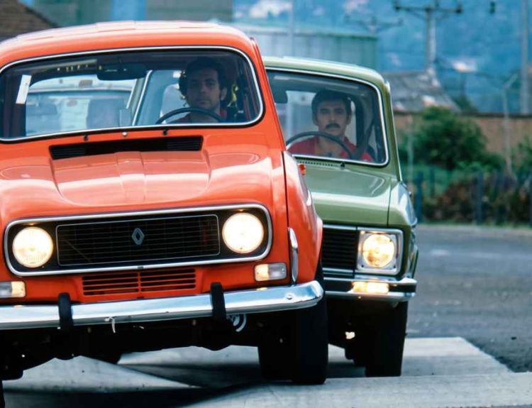Tres clásicos Renault 4, 6 y 12 de colores naranja, verde y azul circulando en fila durante una prueba de ruta en Colombia.