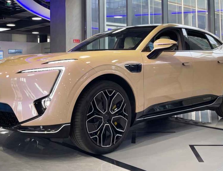 SUV eléctrica premium Avatr 11 de color beige exhibida en un moderno salón de ventas, mostrando su diseño aerodinámico, rines deportivos y cámaras laterales.