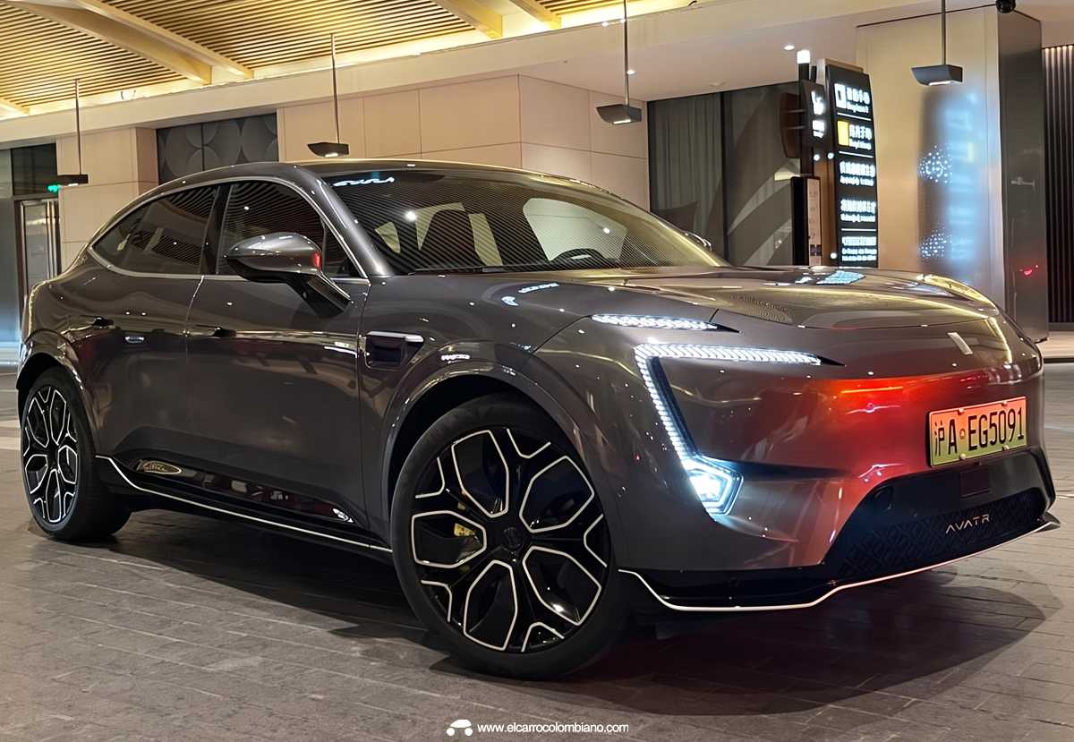Camioneta eléctrica Avatr 11 color gris oscuro exhibida en un concesionario, destacando sus luces diurnas LED en forma de boomerang y diseño futurista.