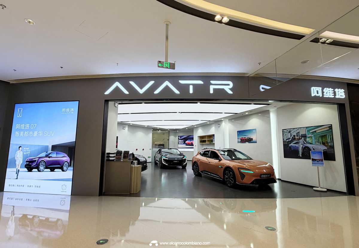 Fachada exterior de un moderno concesionario o boutique de la marca Avatr en Hangzhou, China, en un centro comercial, exhibiendo dos vehículos electrificados de lujo en su interior.