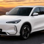 SUV compacto eléctrico Geely EX5 SE de color blanco transitando por una carretera al atardecer frente a montañas en Colombia.