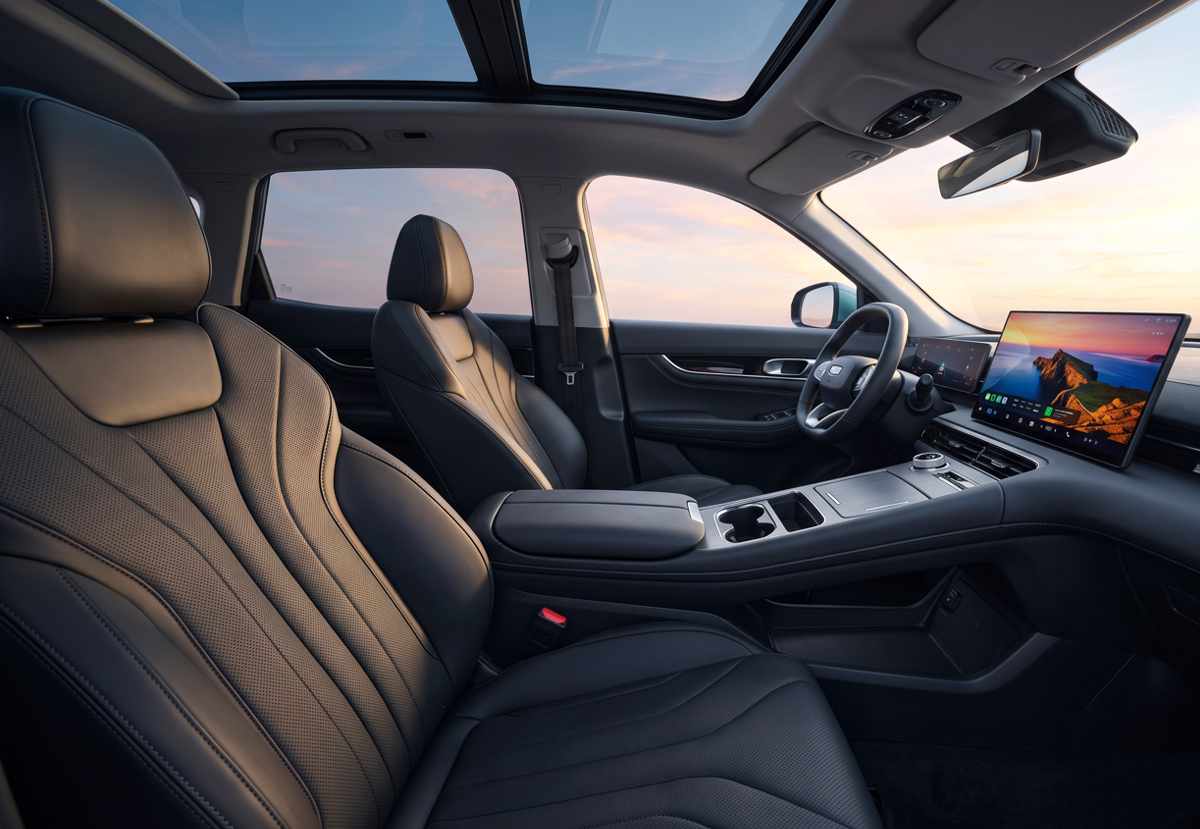 Habitáculo delantero de la Geely EX5 SE mostrando los asientos de cuero sintético negro, el volante multifunción y la pantalla central fija de 15,4 pulgadas.