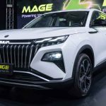 Vista frontal de tres cuartos de la nueva SUV híbrida Dongfeng Huge blanca durante su evento de lanzamiento, destacando su imponente parrilla negra y luces diurnas LED.