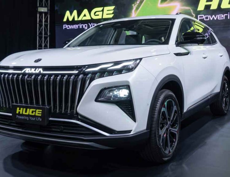 Vista frontal de tres cuartos de la nueva SUV híbrida Dongfeng Huge blanca durante su evento de lanzamiento, destacando su imponente parrilla negra y luces diurnas LED.