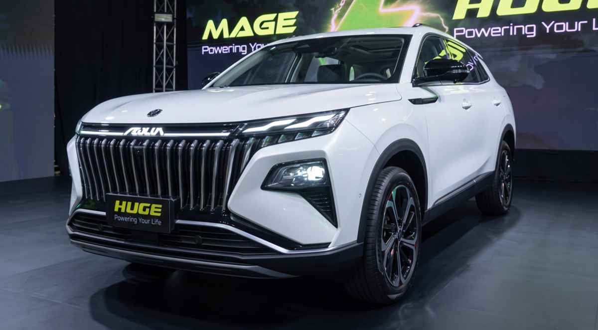 Vista frontal de tres cuartos de la nueva SUV híbrida Dongfeng Huge blanca durante su evento de lanzamiento, destacando su imponente parrilla negra y luces diurnas LED.