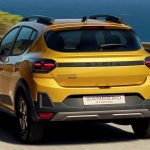 Vista trasera en movimiento del Dacia Sandero Stepway híbrido color amarillo, circulando por una carretera costera iluminada por el sol, destacando sus barras de techo y luces LED.