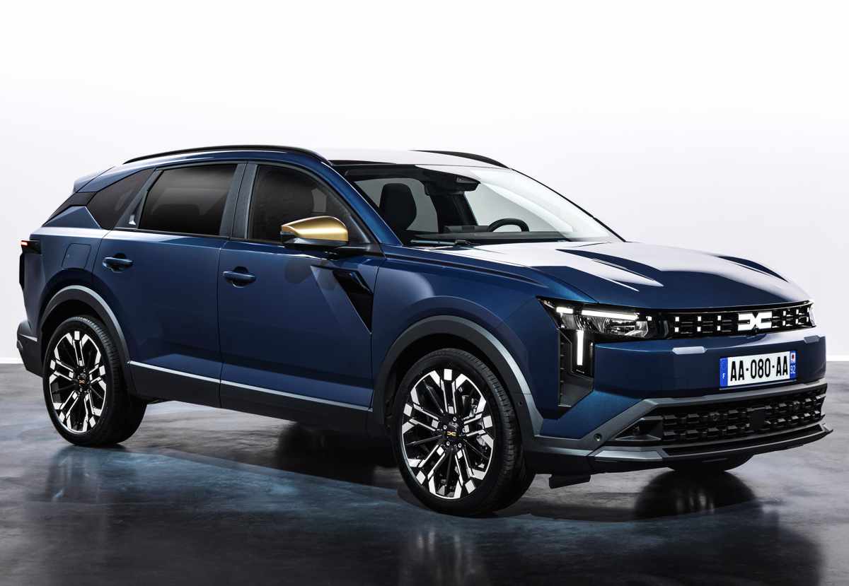 Plano delantero de tres cuartos de la SUV Dacia Striker en color azul oscuro, destacando su nueva parrilla frontal y rines de aleación bitono en un estudio iluminado.
